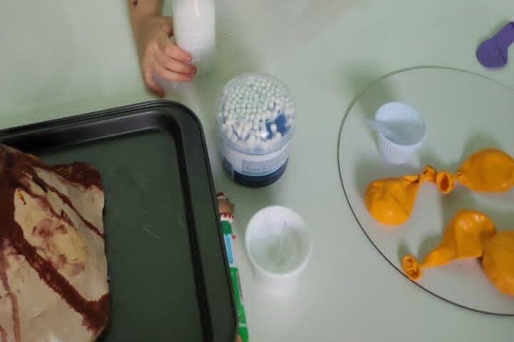 Bandeja da atividade com balões e materiais da oficina