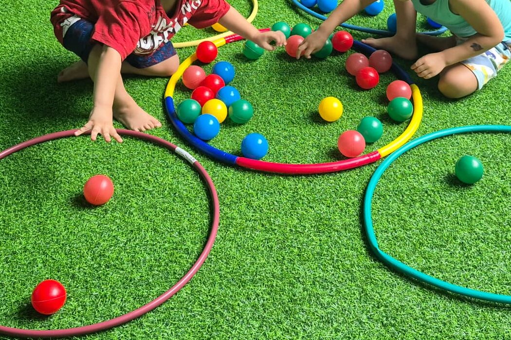 Bolas coloridas e bambolês sobre a grama do Bosque