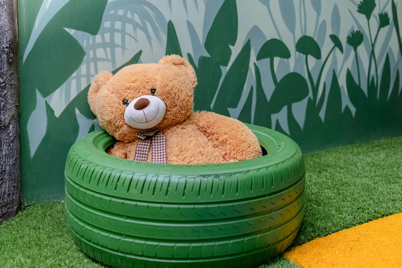 Urso de pelúcia gigante nos pneus verdes